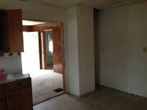 This image shows you the kitchen looking into the living area and toward the front door. You can see the strange bulkhead that floats rather than going all the way to the back wall. 