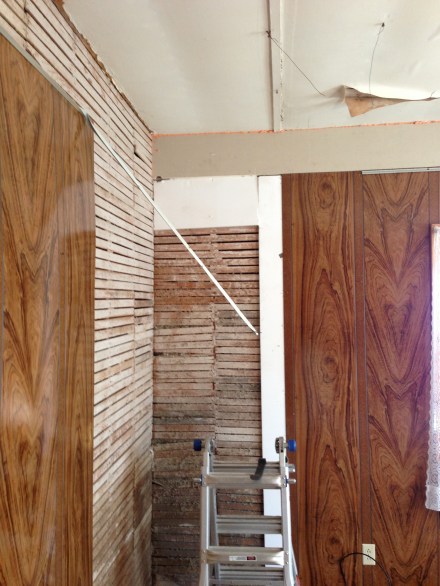 In the living room the fabulous Elvis paneling was nailed directly to the lath. And, we suspect the drop ceiling was installed only because the paneling was 8 feet tall...but the ceiling was taller. So rather than buy more paneling, they added a lovely drop ceiling. 