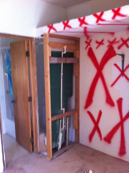 The first floor wall separating the bedroom and living room will go. This wall was the inside of the bedroom closet. You get a great look at the shower that borrows about 18 inches from the closet. 