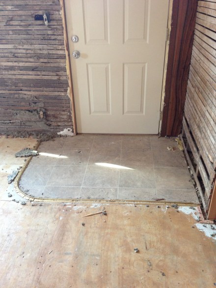 A little island of linoleum greets visitors at the front door.